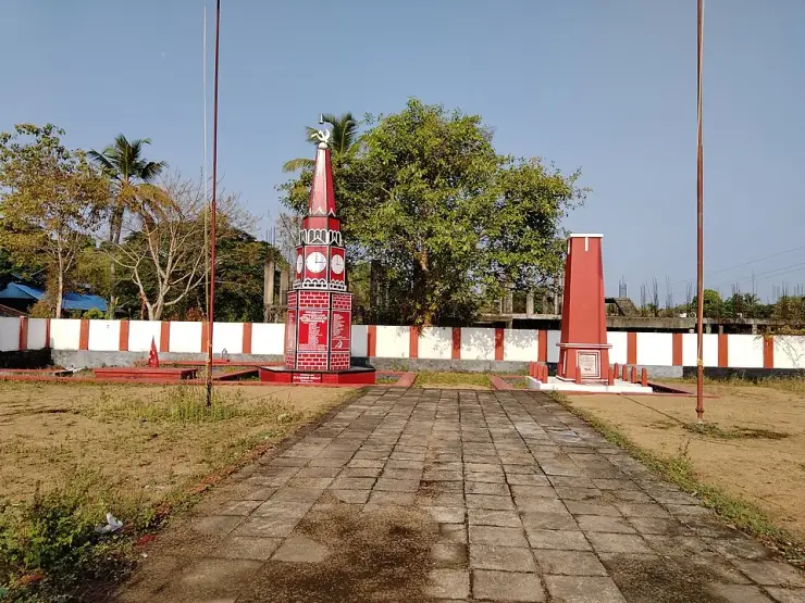 The walled Punnapra Vayalar Rakthasakshi Mandapam enclosure, with a clock-faced obelisk carrying a panel of names