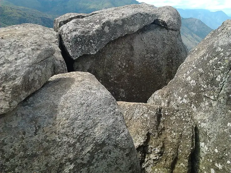 Weathered granite boulders on the Ramakkalmedu ridge in Idukki, Kerala, with the Western Ghats behind