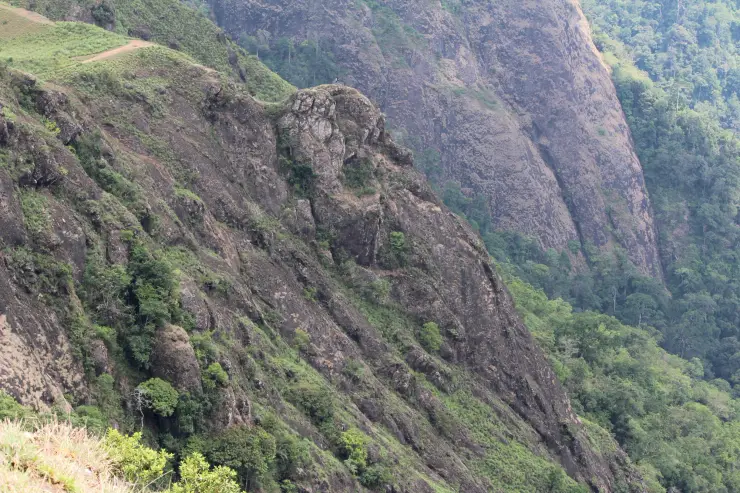 A jutting natural rock profile rises above the wooded valley at Parunthumpara
