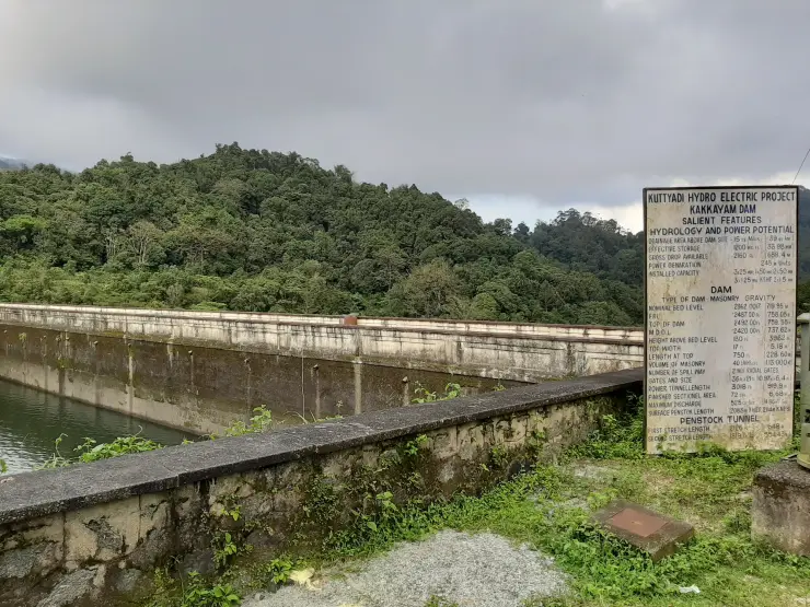 Kuttiady hydroelectric project information board beside Kakkayam dam wall and wooded hills