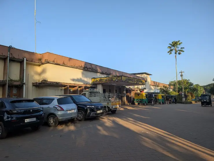 Cars and auto-rickshaws stand outside Kanhangad railway station’s entrance in 2025.