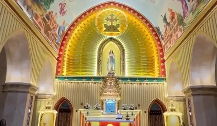 The parish sanctuary’s Marian figure, radiating gold backdrop and painted arched surround.