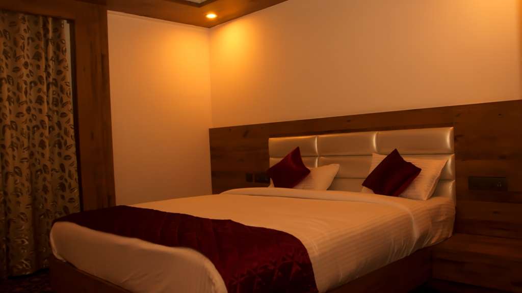 Bed with a red runner in Chembra Peak Resort’s 2018 provider room photograph