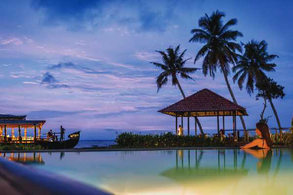 Karma Chakra’s waterfront pool, pavilion and moored boat at dusk