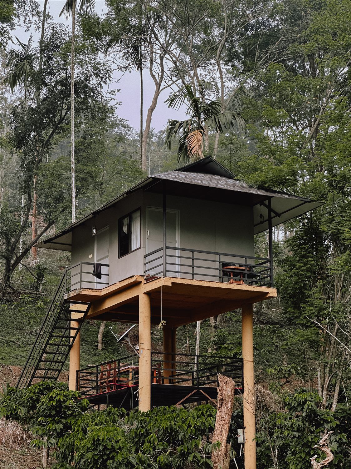 Golpeteo elevated cottage on supporting pillars, with outdoor stairs and a balcony.