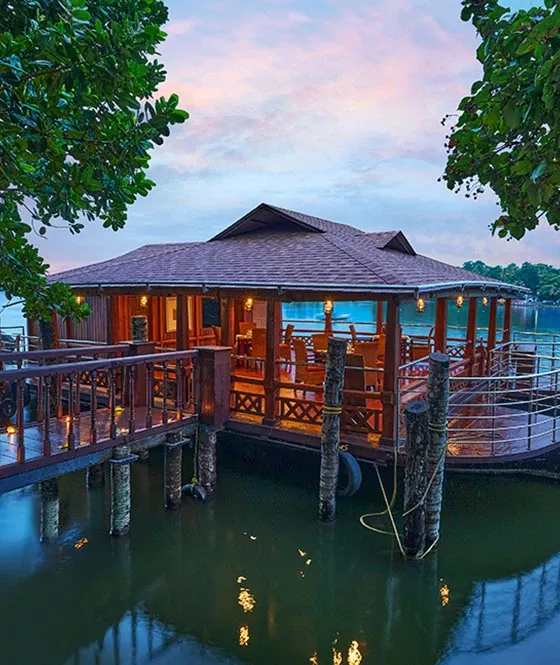 Raanthal, the floating restaurant at The Leela Ashtamudi; confirm current table arrangements directly.