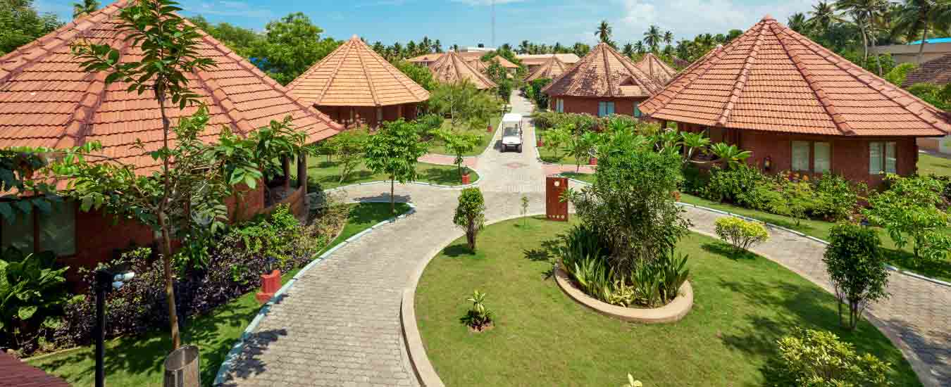 The tiled accommodation buildings and paths shown on Club Mahindra's own Poovar resort page; confirm the unit and entrance offered.