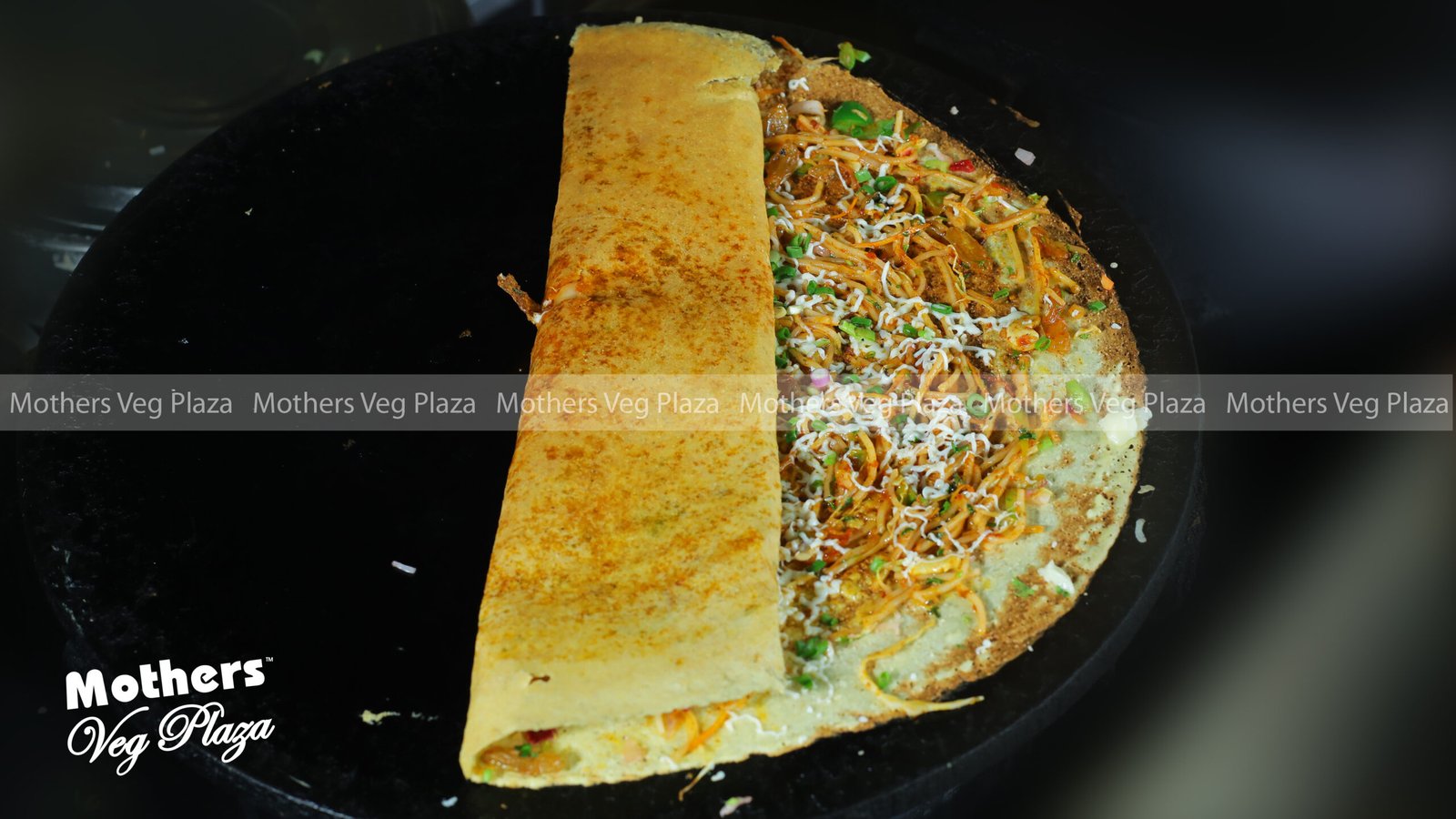 Watermarked dosa photograph published by Mothers Veg Plaza; confirm the dish and serving availability directly.