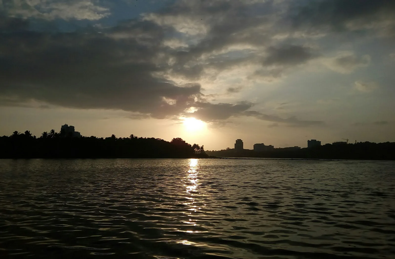 Sunset over Akkulam Lake with the Thiruvananthapuram skyline on the far shore
