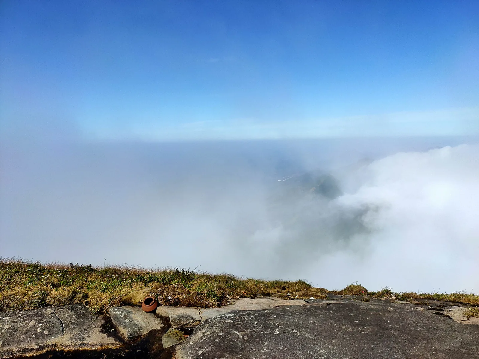 Cloud breaking over the summit rock of Agasthyakoodam with grassland at the edge