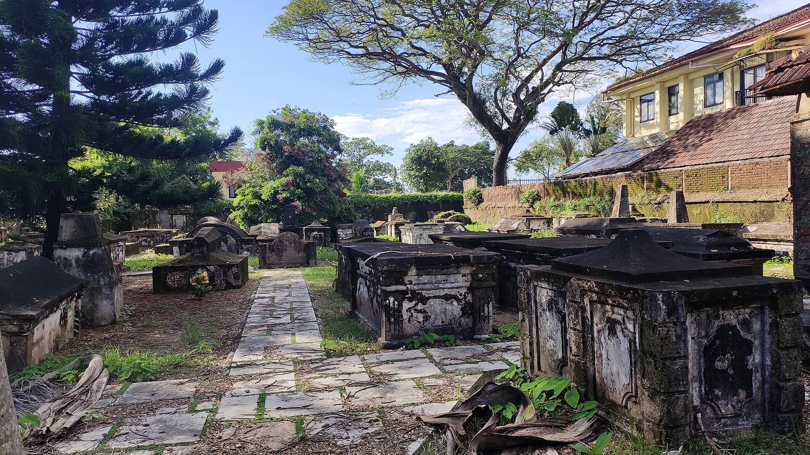 Weathered tombstones inside the walled Dutch Cemetery at Fort Kochi