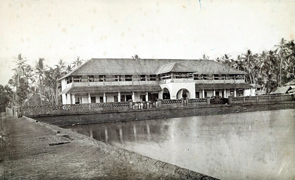 An early photograph of the Mananchira tank at Kozhikode, showing the stepped laterite embankment holding the water and a colonial-era building above it