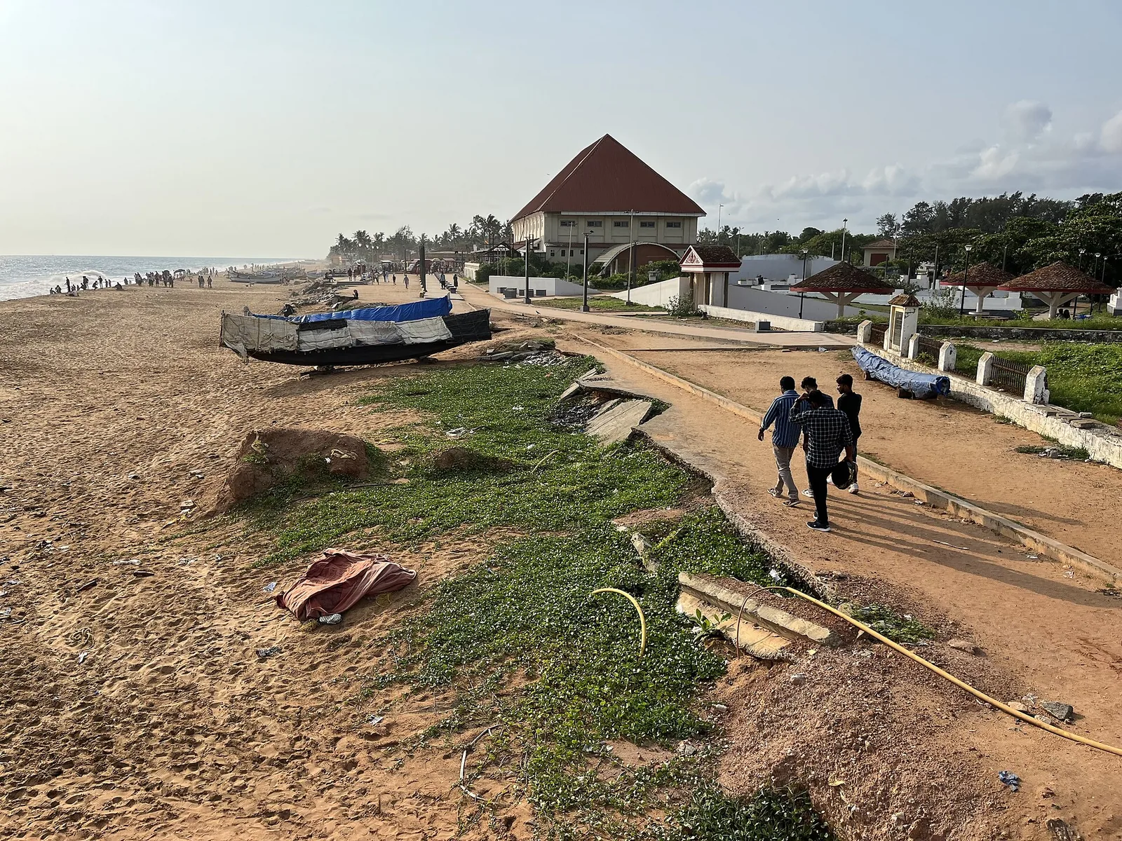 Broken concrete slabs of a former road lying in the sand at Shanghumugham beach