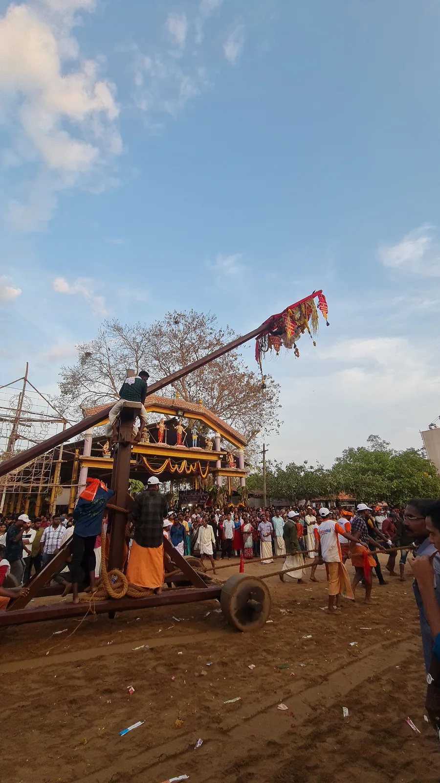 The wheeled Thookam apparatus with its long counterbalanced beam being hauled by a team before a decorated pandal at the Sarkaradevi Temple festival, Chirayinkeezhu