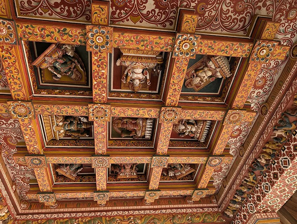 The carved and painted wooden ceiling of the Shiva shrine at Lokanarkavu Temple near Vadakara, with deity figures set in coffered panels