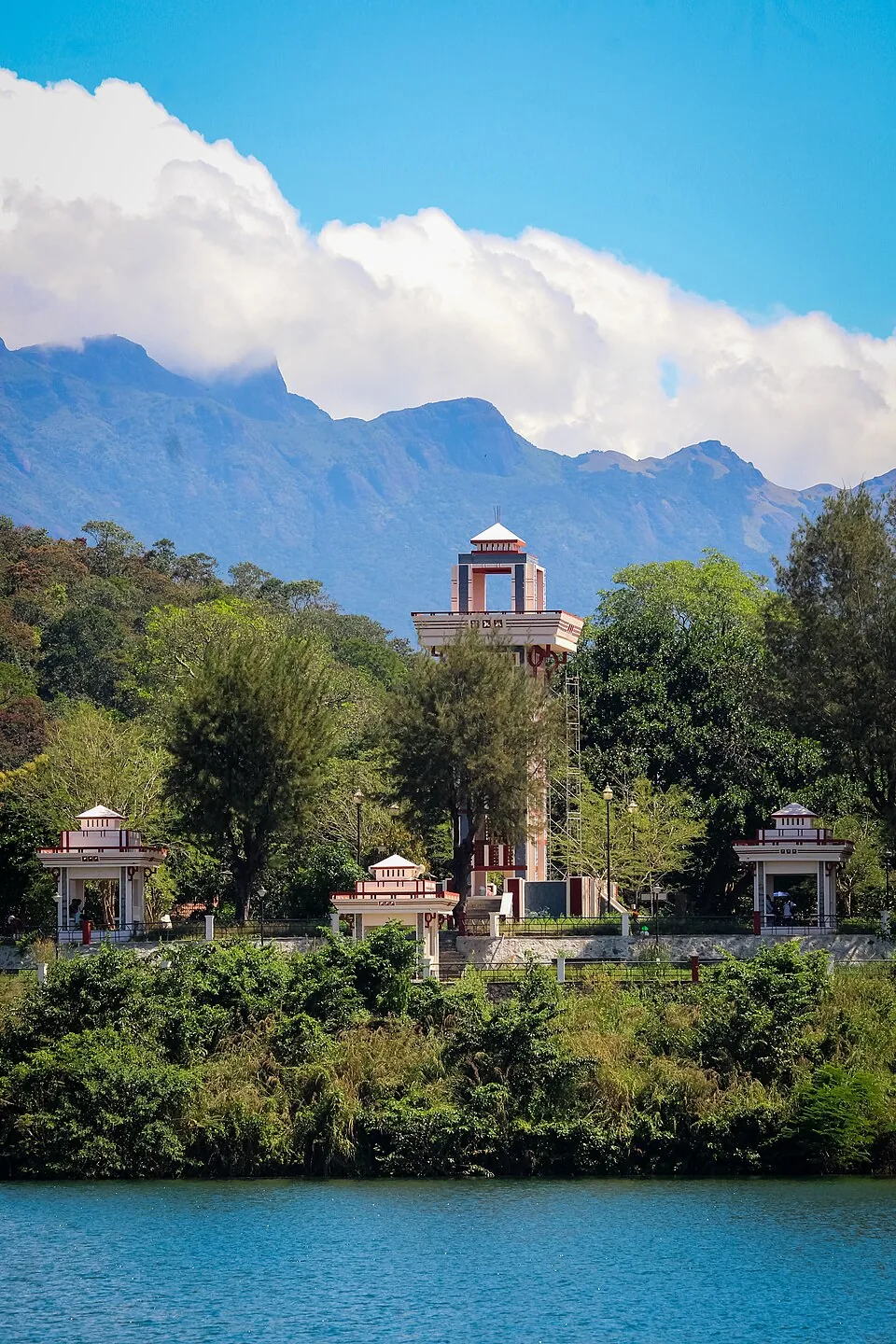 The watch tower and pavilions at Neyyar Dam seen across the reservoir, with the Agasthyamala ridge behind