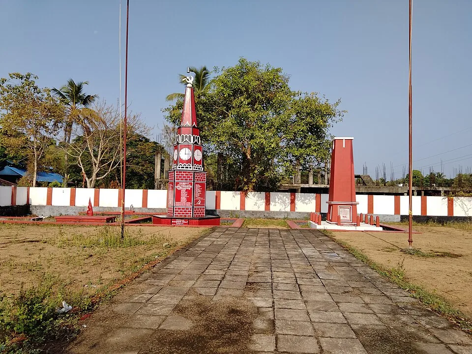 The walled Punnapra Vayalar Rakthasakshi Mandapam enclosure, with a clock-faced obelisk carrying a panel of names