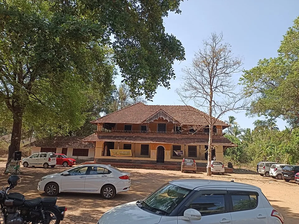 A two-storeyed tiled palace building at Nileshwar with cars parked in front of it