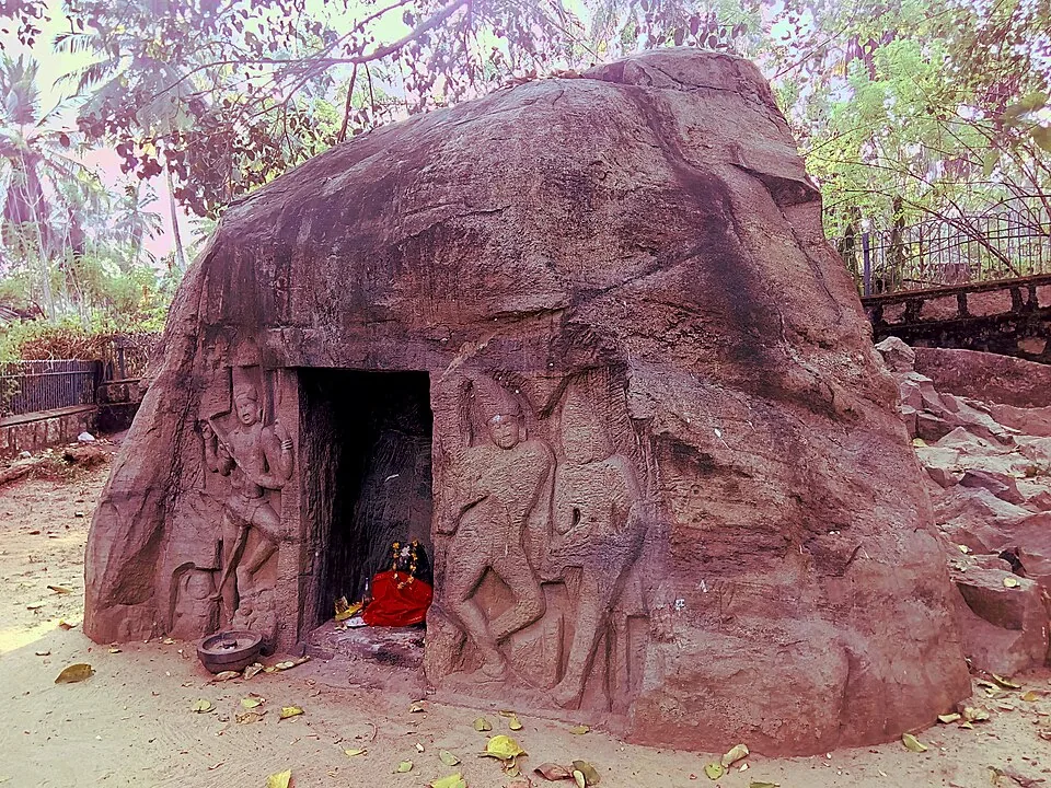The Vizhinjam rock-cut cave shrine, carved into a single boulder, with relief figures flanking the dark doorway