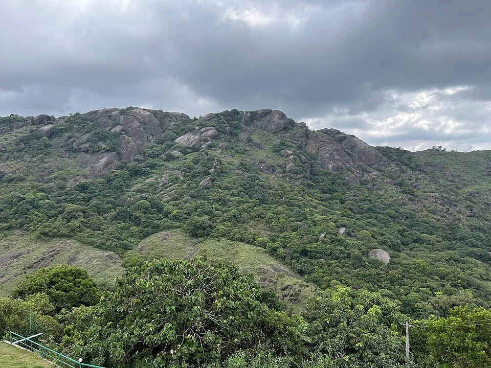Rocky green Vagamon ridge beneath dark rain clouds