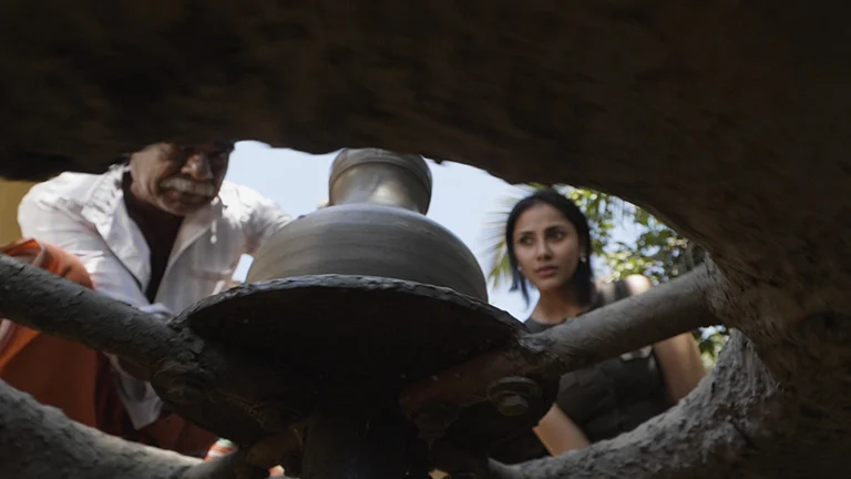 A potter and a visitor watch a clay vessel above a pottery wheel in Kerala Tourism’s Wayanad responsible-tourism photograph.