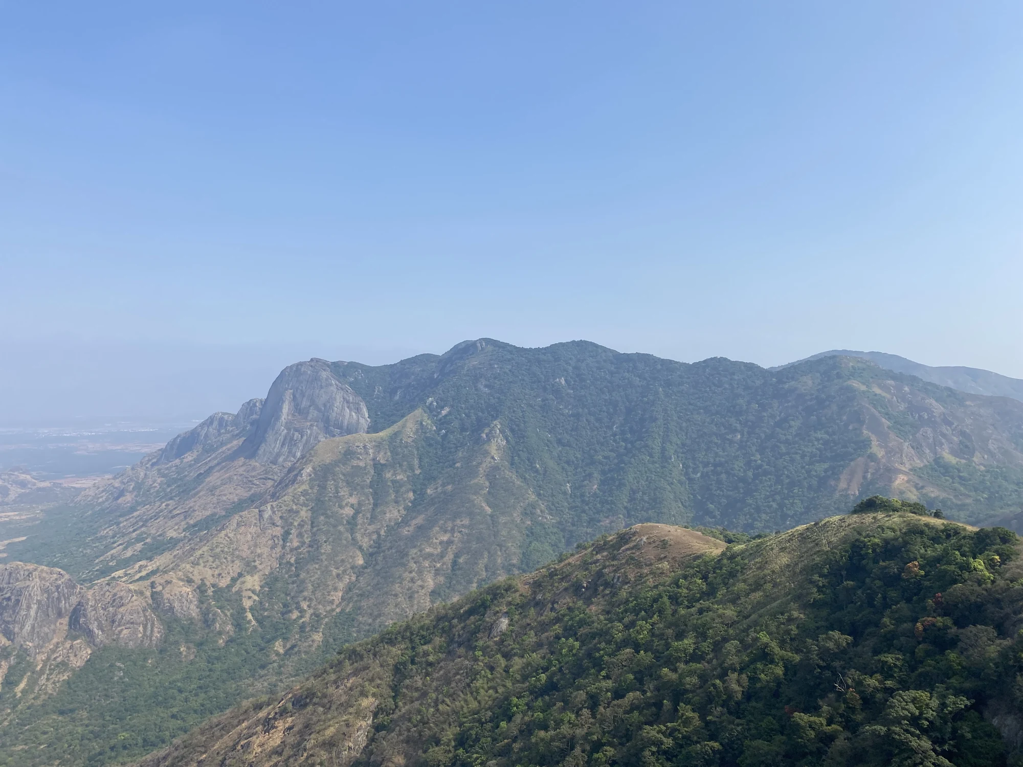 Steep rock faces and wooded ridges seen across the valley from Chathurangapara