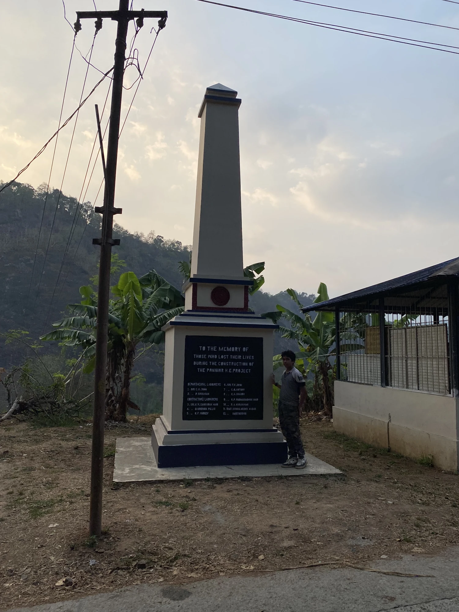 Obelisk beside Ponmudi’s approach with an inscription remembering workers lost during Panniyar project construction
