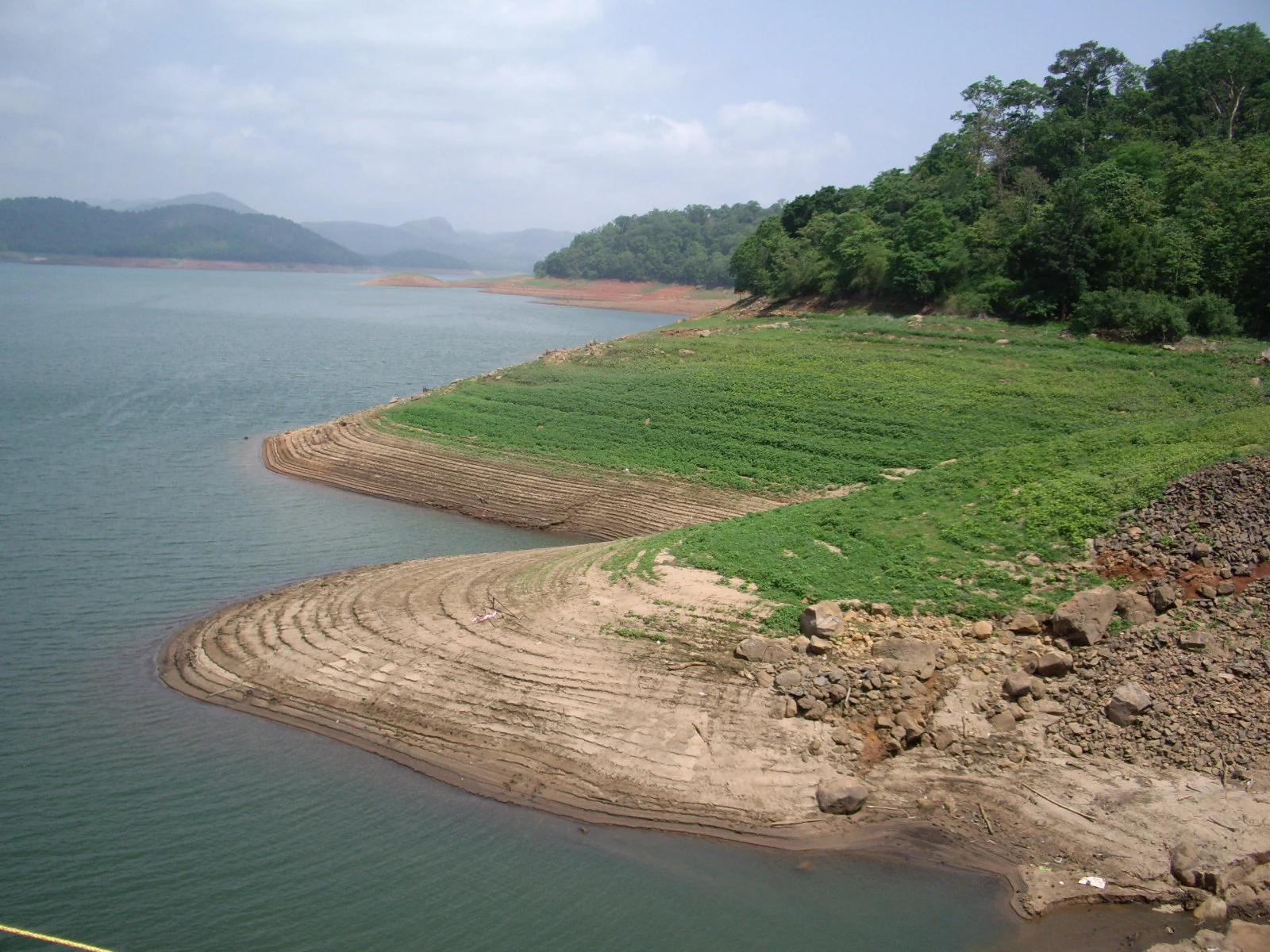 Curved exposed banks and wooded promontories extend into the reservoir at Anchuruli