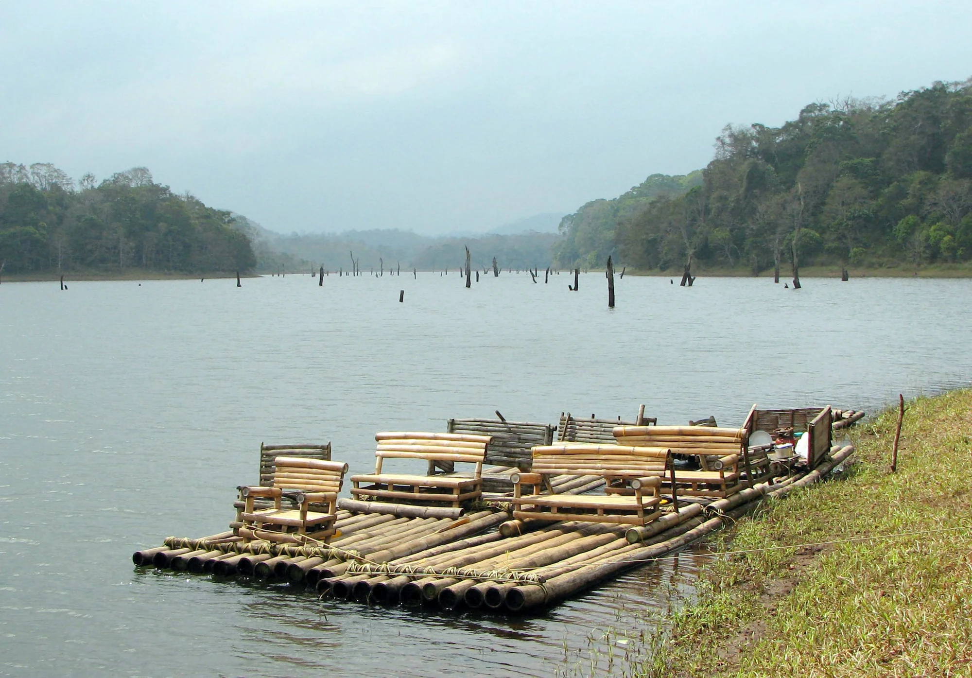 Bamboo rafts with seats are moored beside Periyar Lake in an archival photograph