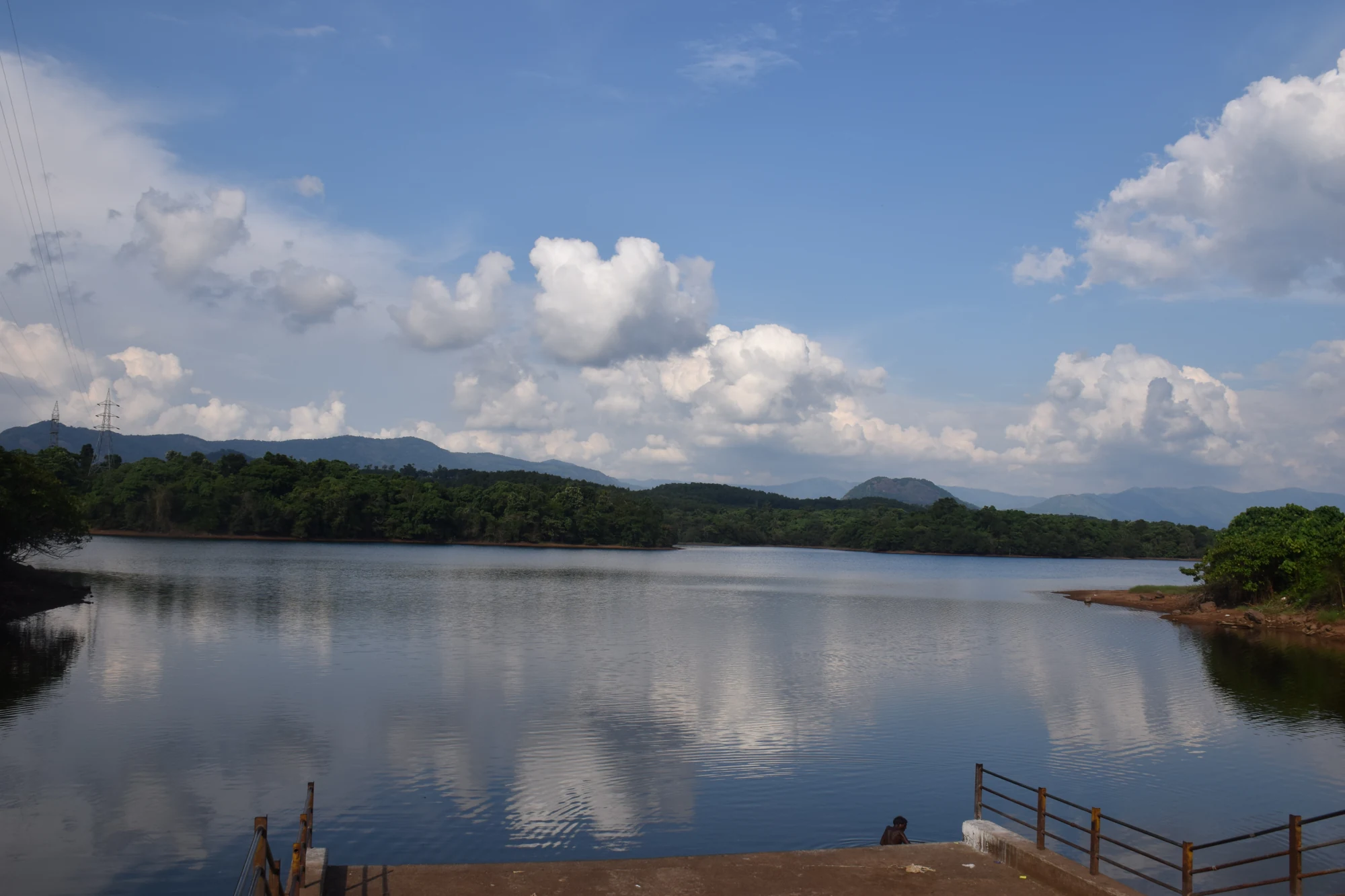 Water and wooded banks beyond a metal-railed platform at Malankara