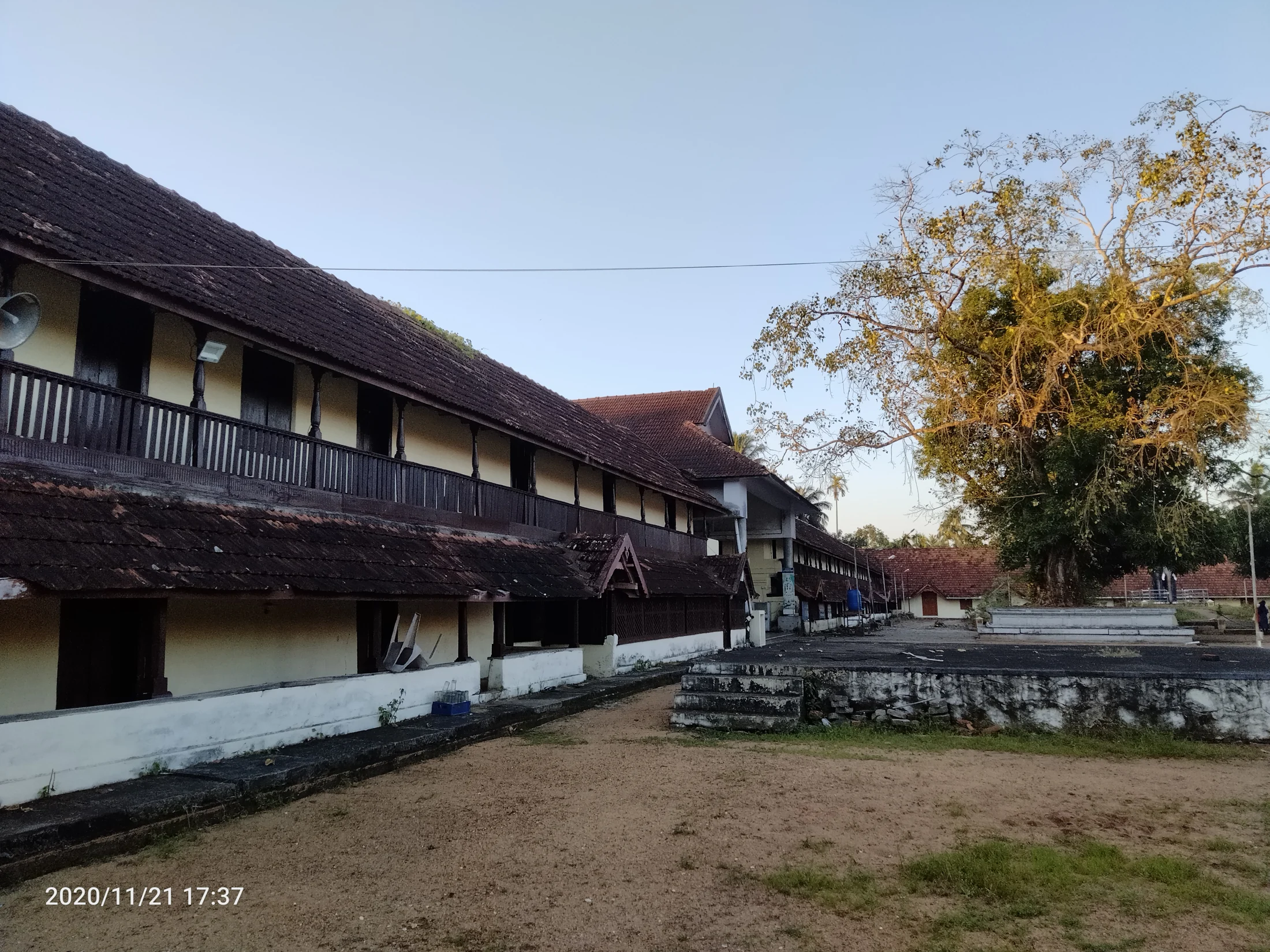 A timber balcony projects beneath layered tiled roofs at Ambalappuzha temple.
