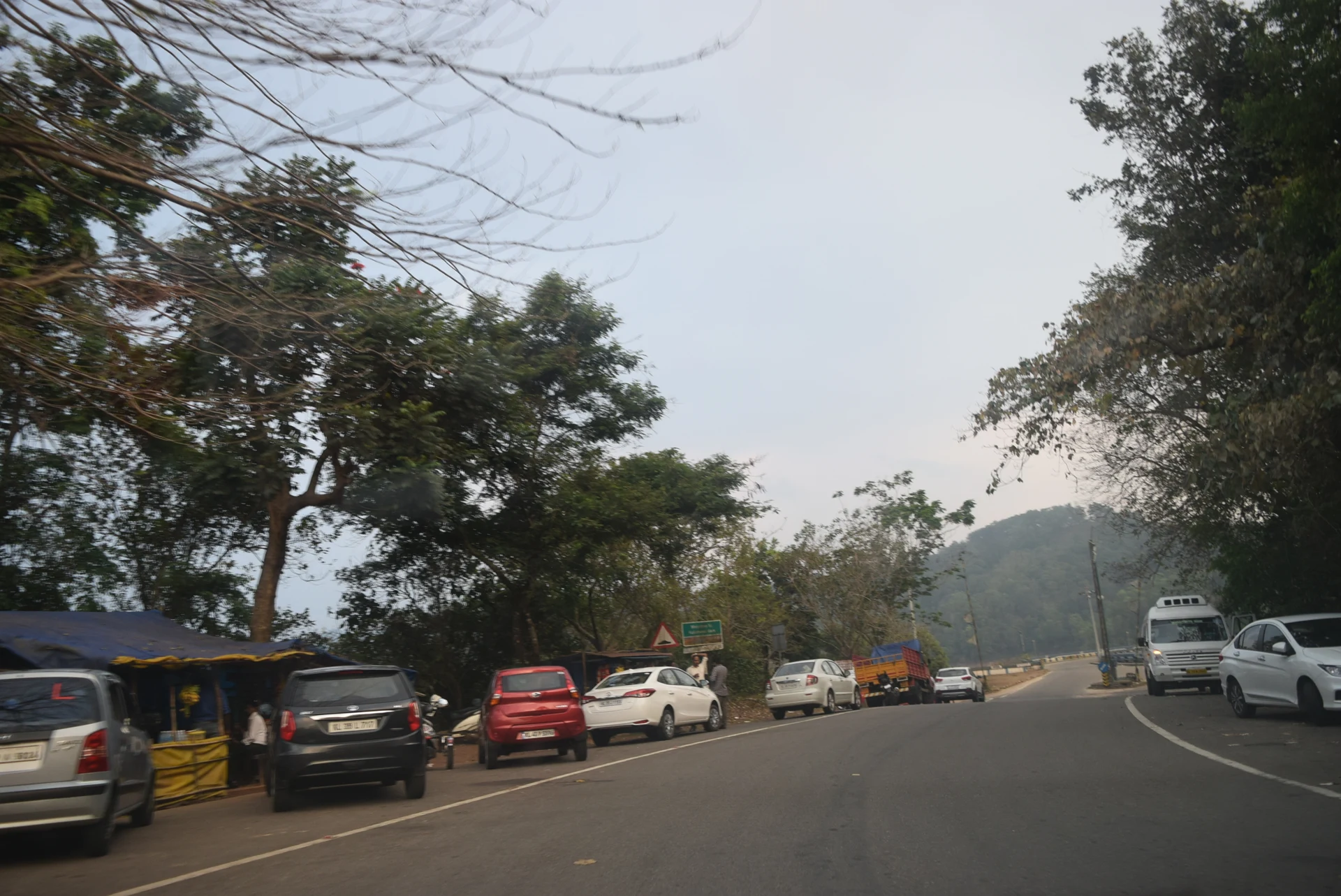 A historical view of vehicles and roadside stalls at Kulamavu; current parking restrictions differ.